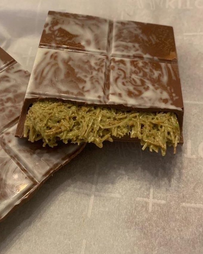 Dubai-style chocolate bar broken open to reveal pistachio kataifi filling